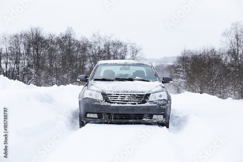 The car stands on a snow-covered road