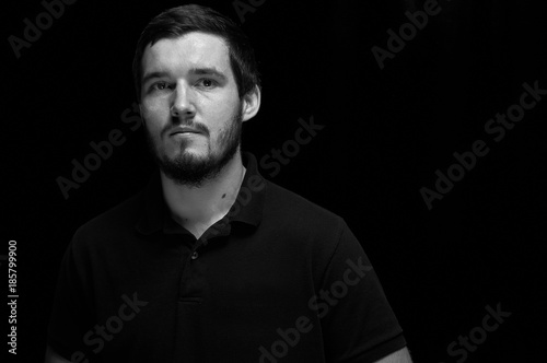 Confident and strong young man with beard in black and white