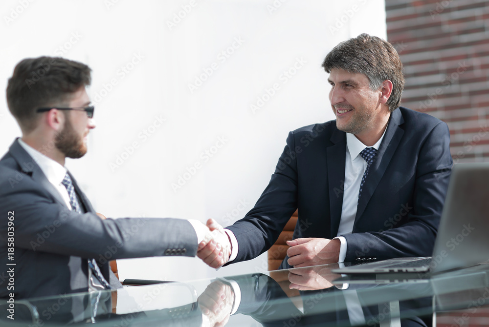 Two business colleagues shaking hands during meeting Two business colleagues shaking hands during meeting