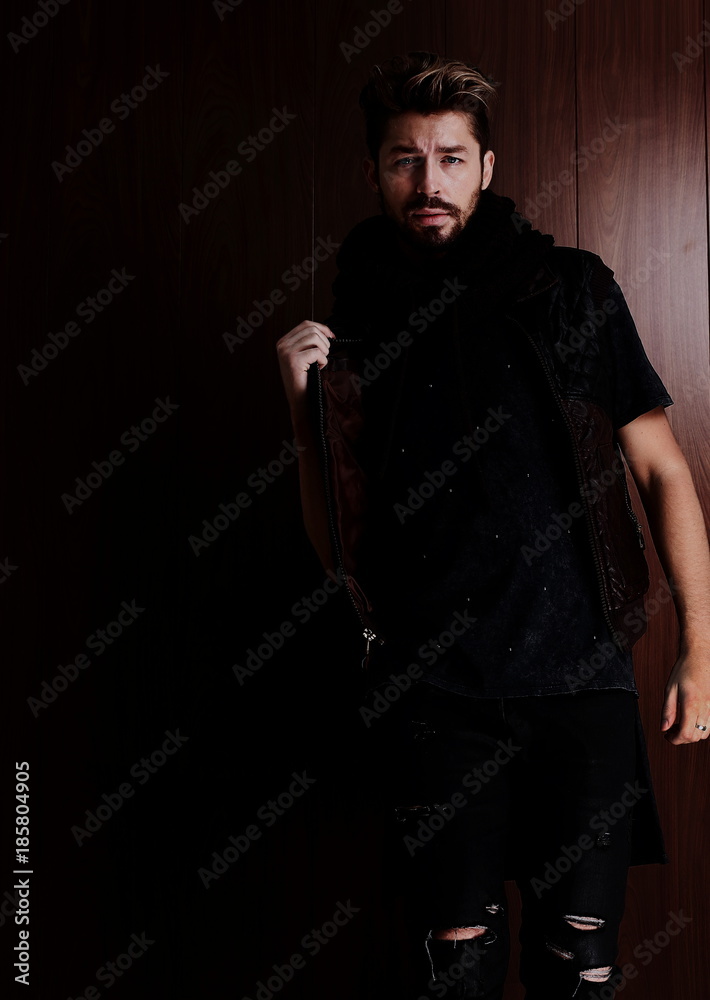 Handsome confident mature man with beard stands on wooden brown Handsome confident mature man with beard stands on wooden brown
