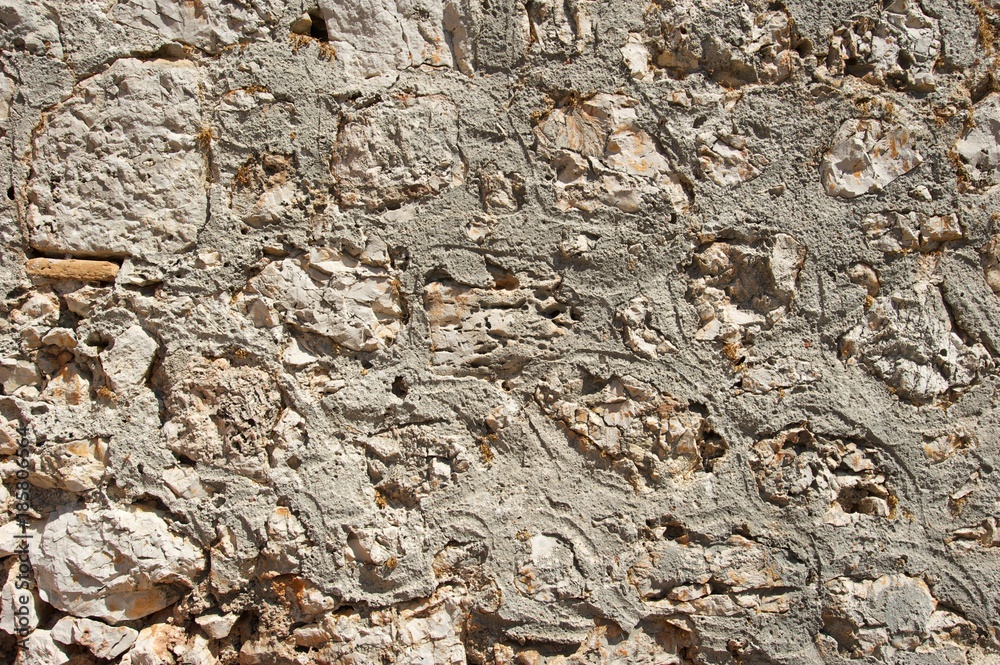 Fototapeta premium Genoese fortress wall fragment. Old stonewall. Textured background. Rocks and concrete.