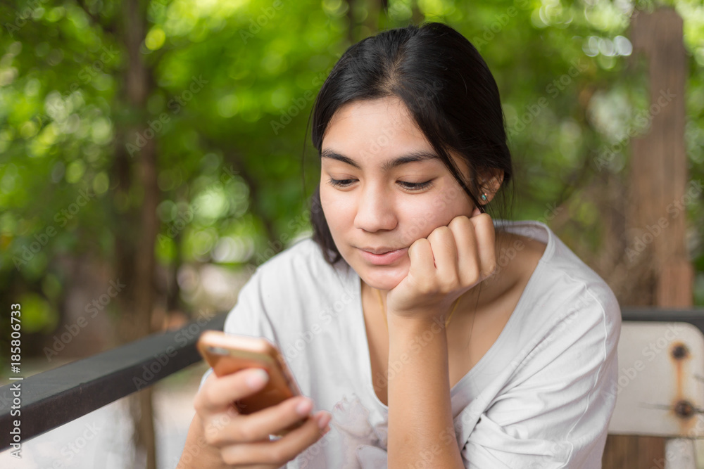 Asian woman playing with smartphone in cafe shop
