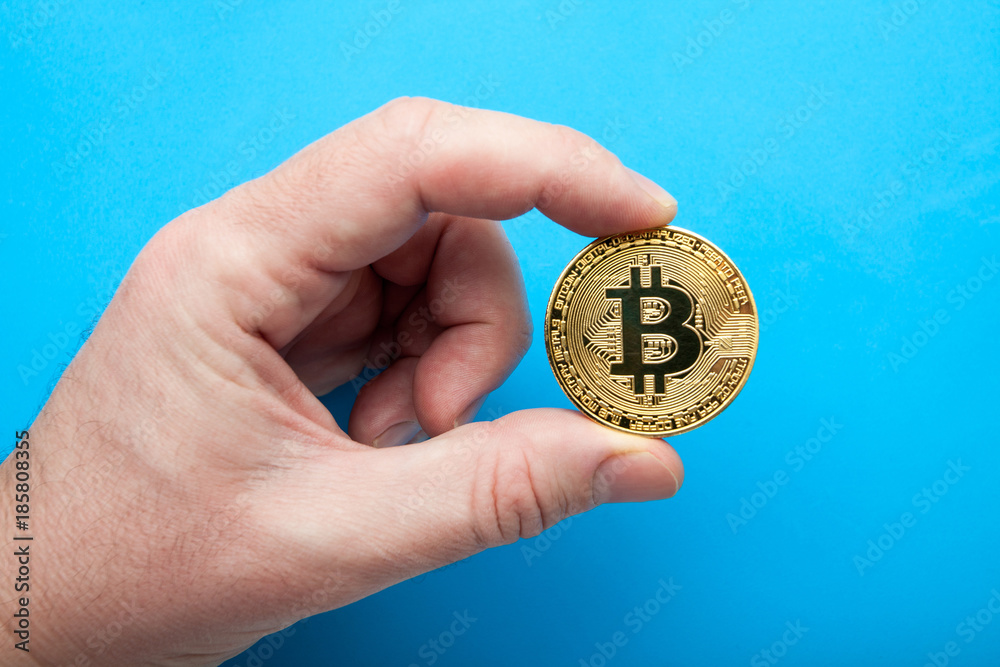 Crypto currency The bitcoin in hand on a blue background. Crypto currency The bitcoin in hand on a blue background.
