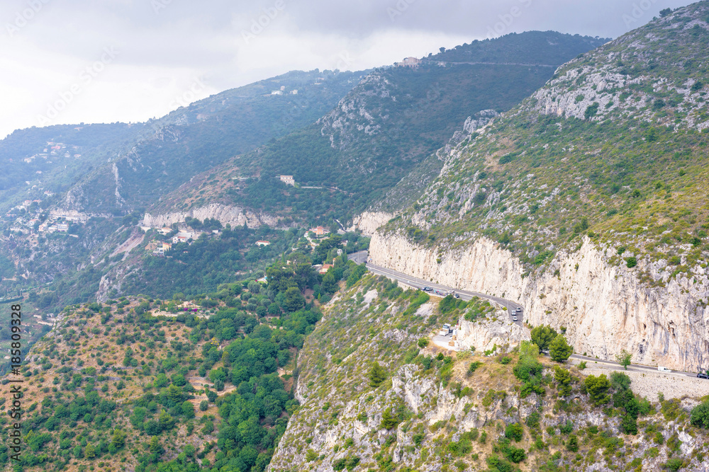 Fototapeta premium Daylight foggy view to Eze village, trees and mountains