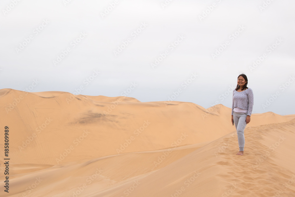 Indonesian girl posing on Dune 7 in Walvis Bay, Namibia