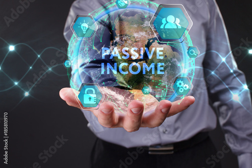 The concept of business, technology, the Internet and the network. A young entrepreneur working on a virtual screen of the future and sees the inscription: Passive income