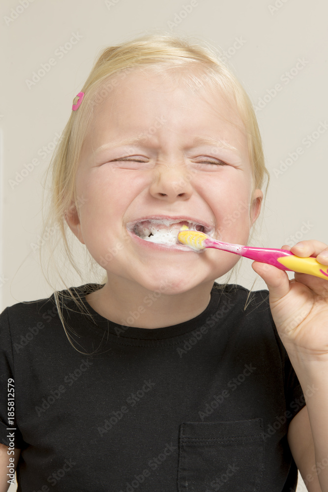 Smiling Little Girl in Black Shirt Brushing Her Teeth Smiling Little Girl in Black Shirt Brushing Her Teeth