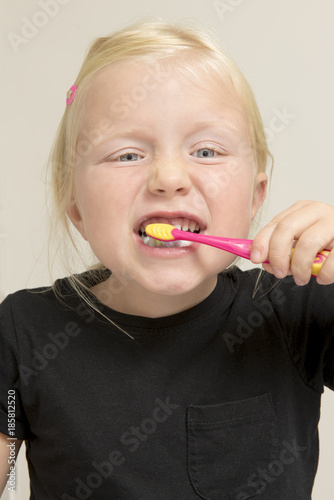 Little Girl Brushing Her Teeth with a Pink Toothbrush