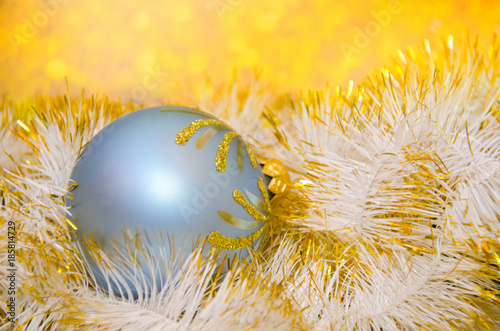 Blue ball and golden tinsel against an abstract blurred golden background (shallow DOF, selective focus), with copy space for your text photo