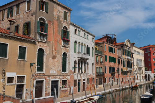 Traditional narrow canal street with gondolas and old houses in Venice, Italy. Architecture and landmarks of Venice. Beautiful Venice postcard. © djevelekova