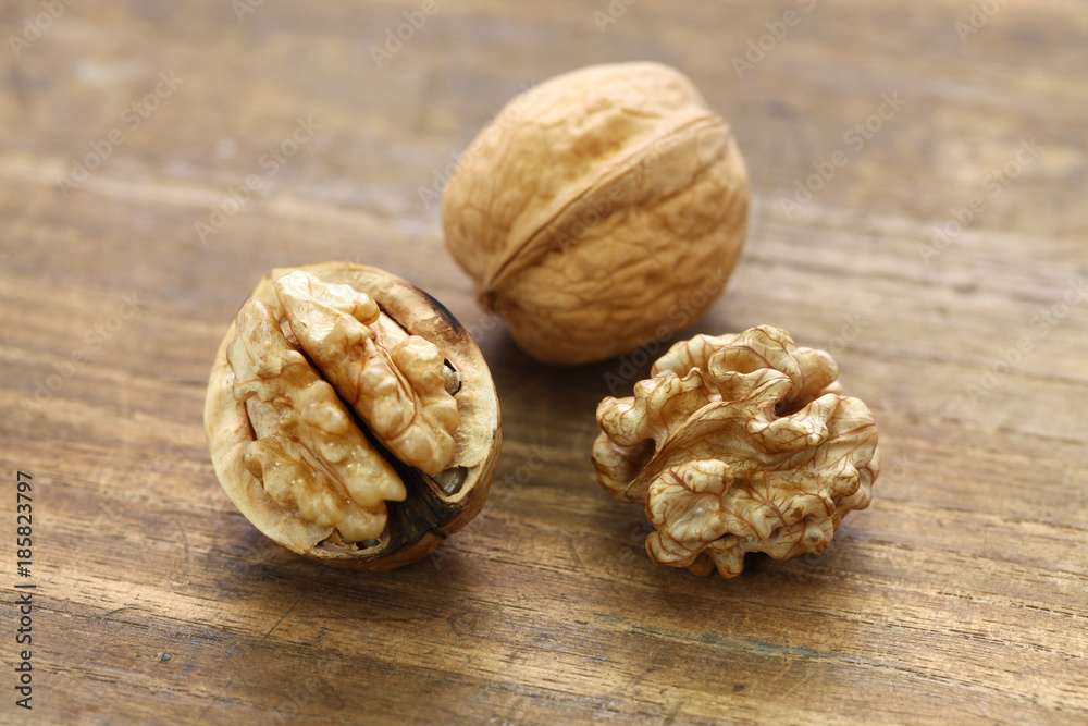 walnuts, kernel and shell on wooden background