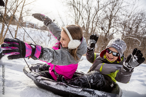 Children having fun sledding outdoors during winter.