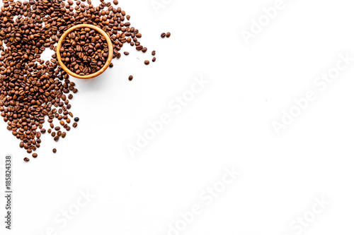 Fresh roasted coffee beans in bowl on white table top view copyspace. Coffee background.