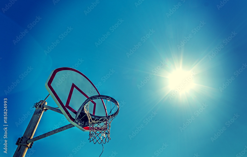 Sun shining over a basketball hoop