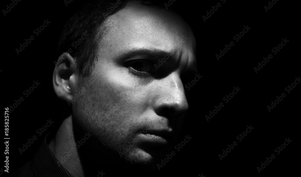 Young man face black background, low key Young man face black background, low key