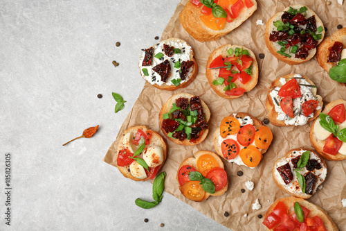 Tasty bruschettas with tomatoes on grey background