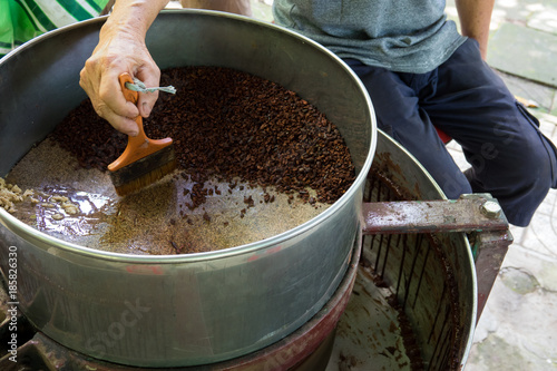 A farmer makes raw cocoa handmade with a machine at home. Can Tho city, Vietnam