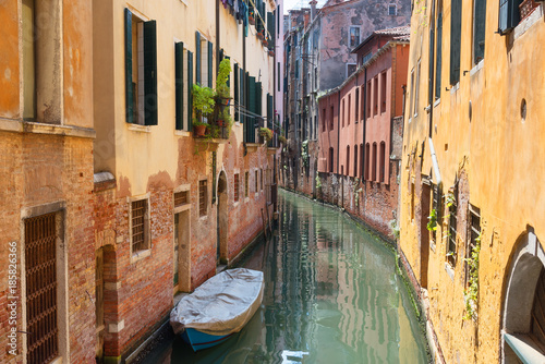 Traditional narrow canal street with gondolas and old houses in Venice, Italy. Architecture and landmarks of Venice. Beautiful Venice postcard. © djevelekova