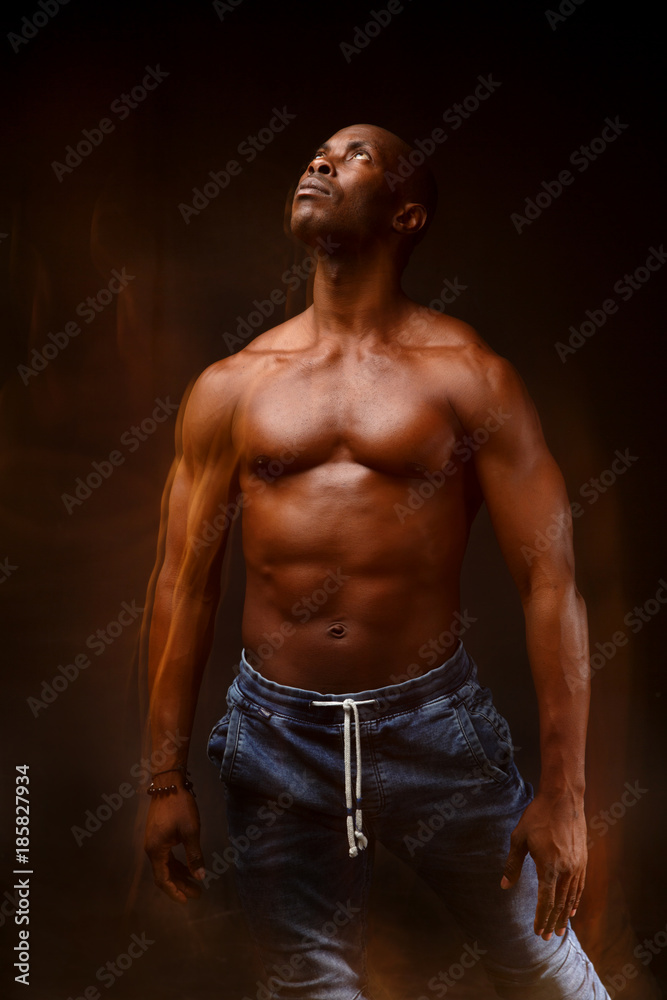 Dancing black man on a black background with a mixed light.