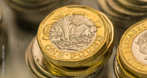 Close up focus photos of new United kingdom Pound coin, among other British coins photo