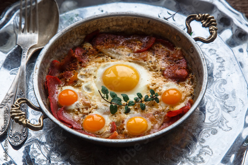 Traditional turkish breakfast with eggs and pastirma, with tea and metal dishware photo