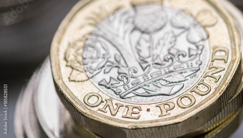 Close up focus photos of new United kingdom Pound coin, among other British coins photo