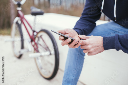 Male BMX rider on street with phone