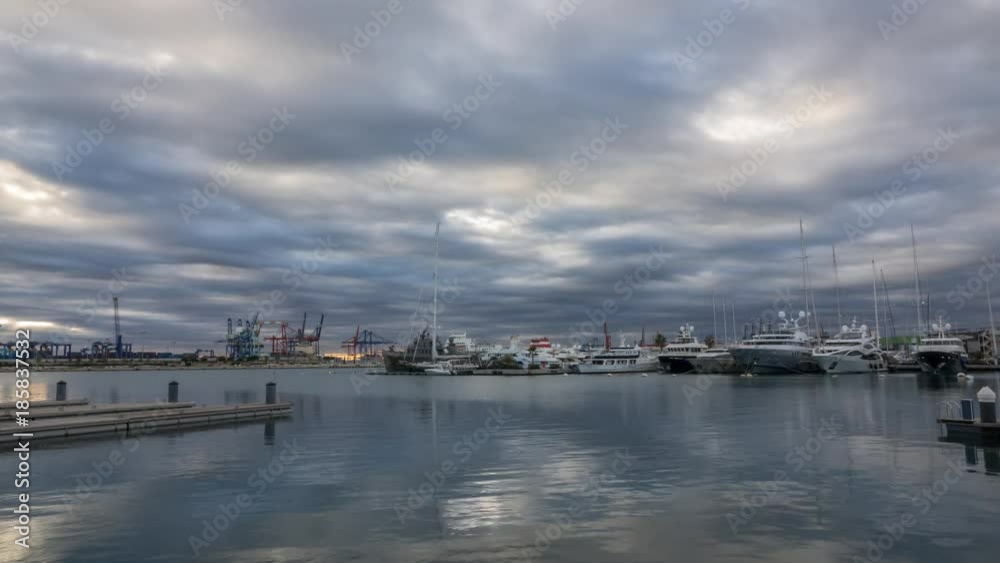 port twilight in the Valencia harbor cranes working loading transport ships, time lapse reflection in water wide angle, panoramic port twilight in the Valencia harbor cranes working loading transport ships, time lapse reflection in water wide angle, panoramic