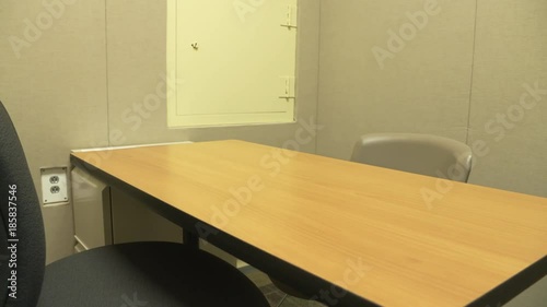 POV dolly movement shot entering a jail interview or interrogation room for criminal questioning by police. ProRes file, shot in 4K UHD.