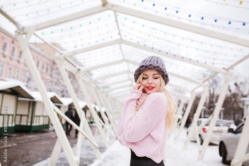 Sensual young woman wearing knitted hat and sweater, posing at the street in winter. Empty space Sensual young woman wearing knitted hat and sweater, posing at the street in winter. Empty space