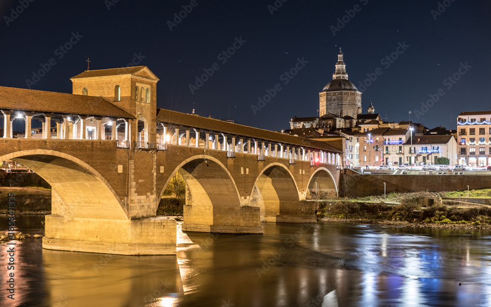 Night view of Pavia with Ponte Coperto and the river Ticino