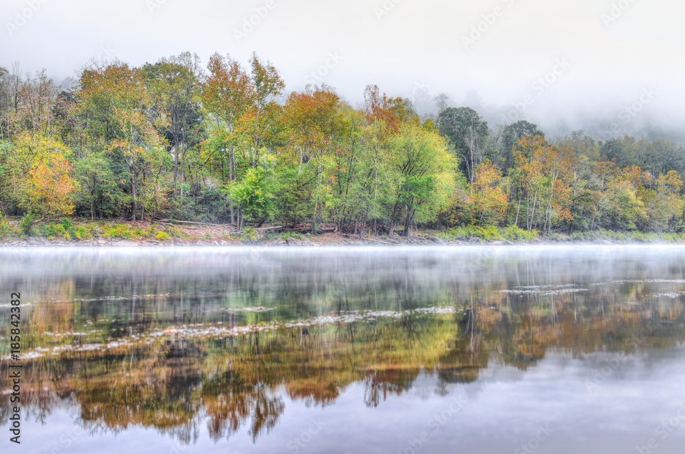 New River Gorge water river lake during autumn golden orange foliage in fall by Grandview with peaceful calm tranquil morning bright mist fog