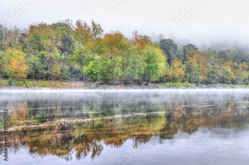 New River Gorge water river lake during autumn golden orange foliage in fall by Grandview with peaceful calm tranquil morning bright mist fog