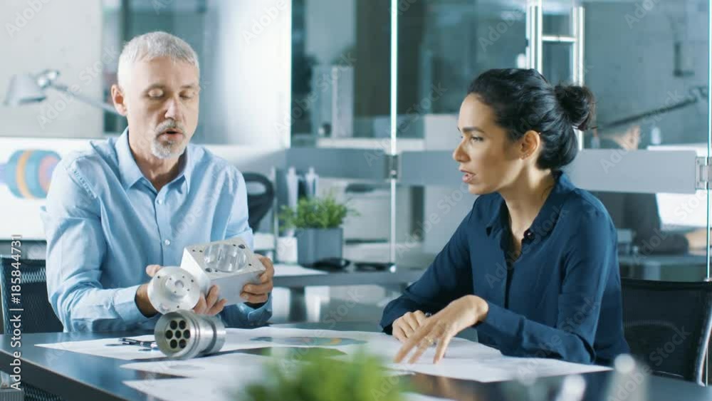 Experienced Male and Female Industrial Engineers have Discussion, They Work on a Machinery Component Design. They Office is Stylish and Modern Looking. Shot on RED EPIC-W 8K Helium Cinema Camera. Experienced Male and Female Industrial Engineers have Discussion, They Work on a Machinery Component Design. They Office is Stylish and Modern Looking. Shot on RED EPIC-W 8K Helium Cinema Camera.
