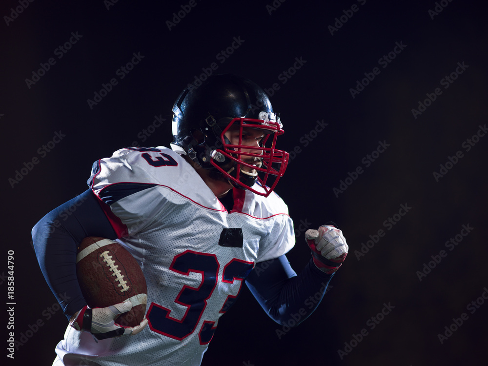 American football player holding ball while running on field American football player holding ball while running on field