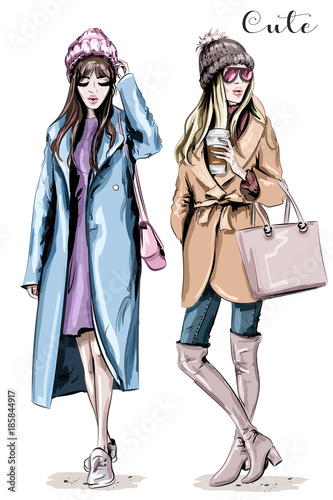 Two fashion women. Hand drawn stylish beautiful women in winter clothes. Fashion winter outfits. Sketch.