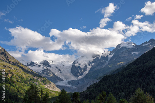 mountain peaks covered with snow, beautiful alpine landscape with glacier, blue sky with clouds