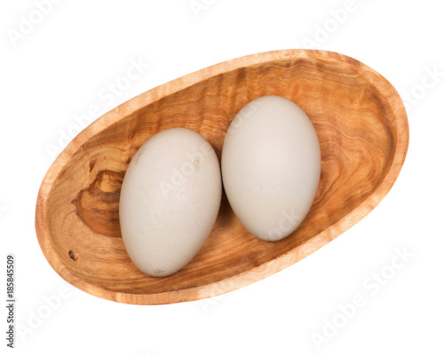 Unwashed fresh organic gmo and soy free pasture raised chicken eggs in wooden bowl isolated on white background