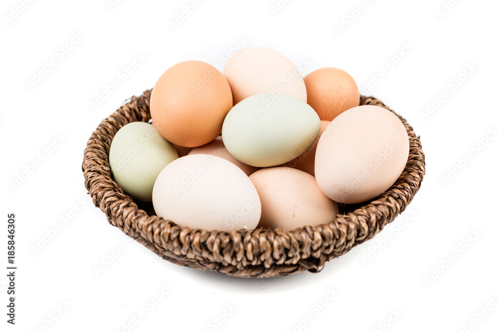 Farm fresh eggs in a basket on a white background Farm fresh eggs in a basket on a white background