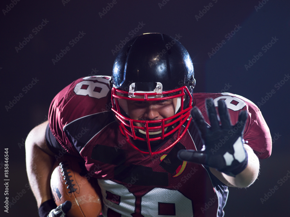 American football player holding ball while running on field