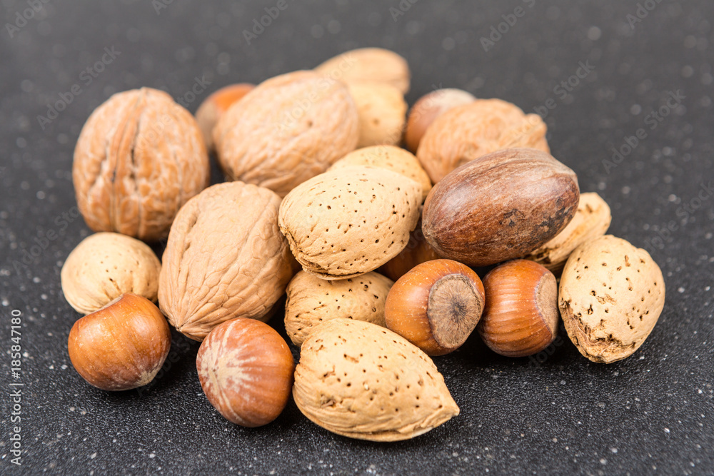 Mixed nuts in shell on a black background Mixed nuts in shell on a black background
