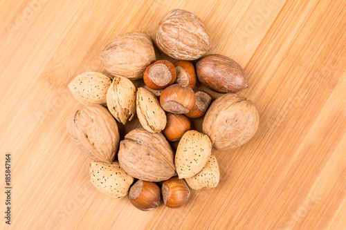 Mixed nuts in shell on a wood background photo