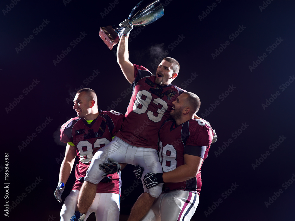 american football team with trophy celebrating victory