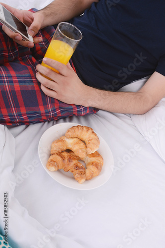Man having breakfast and using phone.
