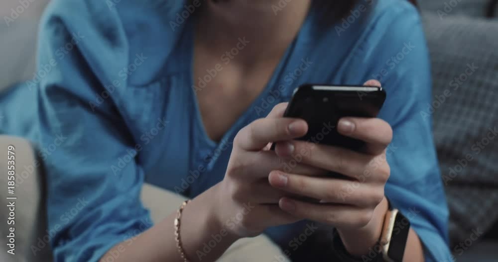 Close up face woman uses smartphone lying on the sofa in home smiling apartment christmas communication christmas tree hold house internet lifestyle modern technology relax rest message slow motion
