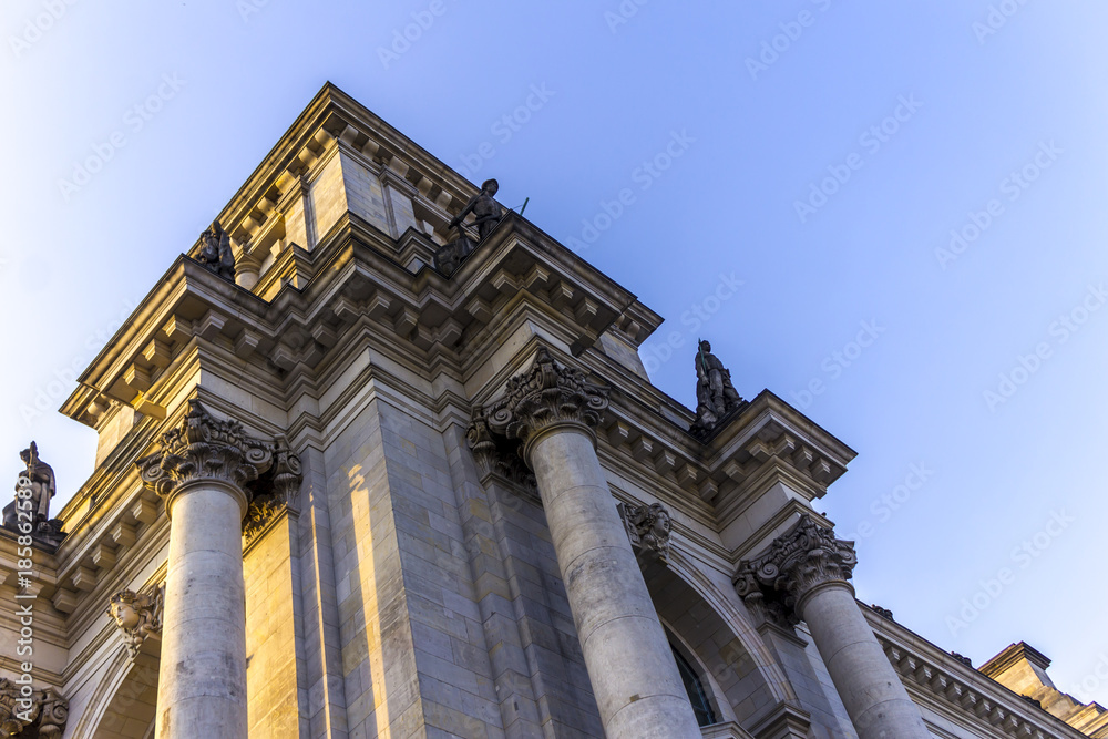 Detail of the facade of the Reichstag building. Blue sky and grey stones. Berlin, Germany .