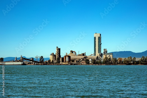 Cement Factory at the waterfrant of Fraser River at the bacground of blue sky and mountain range