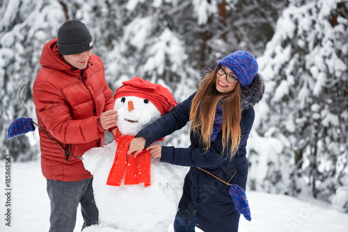 winter fun. a girl and a man making snowballs.