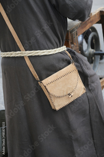friar with leather handbag with and a brown wax in a medieval reenactment