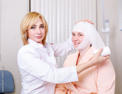 Doctor makes a bandage on head patient at clinic © Georgii